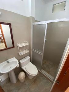 a bathroom with a shower and a toilet and a sink at Fitzcarrald Hotel in Iquitos