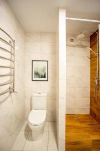La salle de bains blanche est pourvue d'une douche et de toilettes. dans l'établissement Luxury Apartment with 2 bedrooms in the city center, à Mykolaïv