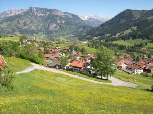 ein Dorf auf einem Hügel mit Bergen im Hintergrund in der Unterkunft Ferienwohnungen Kappeler in Bad Hindelang