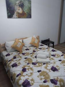 een slaapkamer met een bed met paarse bloemen erop bij Aparthotel Sweet Home Acasa in Constanţa