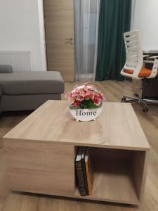 ein Wohnzimmer mit einem Couchtisch mit Blumen darauf in der Unterkunft Aparthotel Sweet Home Acasa in Constanţa