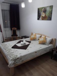 een slaapkamer met een groot bed en een schilderij aan de muur bij Aparthotel Sweet Home Acasa in Constanţa
