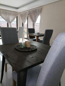 a dining room table with chairs and a wooden table at HWH Guesthouse Middelburg in Middelburg