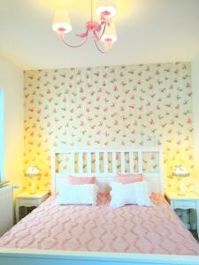 um quarto com uma cama rosa e duas mesas em Romantic Style Apartment Titisee-Neustadt em Titisee-Neustadt