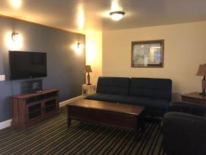 ein Wohnzimmer mit einem Sofa und einem Flachbild-TV in der Unterkunft Pacific Reef Hotel & Light Show in Gold Beach