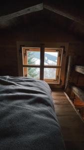 a bed in a room with a large window at Berghütte Wattenberg in Wattenberg