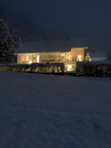 une maison éclairée dans la neige la nuit dans l'établissement DAS Max, à Dalaas