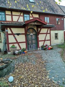 dom ze stodołą z liśćmi przed nim w obiekcie Appel-Ranch w mieście Bockelwitz