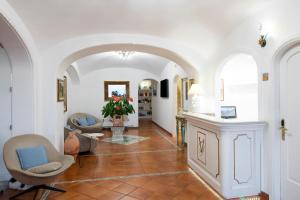 un soggiorno con arco, sedie e tavolo di Hotel Villa Gabrisa a Positano