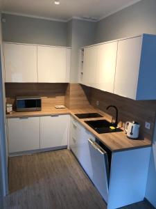 - une cuisine avec des placards blancs et un évier dans l'établissement Baltic Blue Apartamenty Pobierowo, à Pobierowo