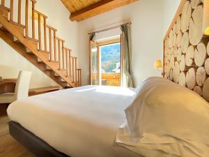 a bedroom with a large bed and a staircase at Boutique Hotel Il Riccio - Adults Only in Roccaraso