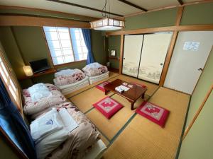 una vista aérea de una habitación con 2 camas y una mesa en Nozawa Dream Central, en Nozawa Onsen