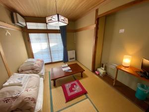 Habitación pequeña con cama y mesa en Nozawa Dream Central, en Nozawa Onsen