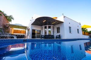 a house with a swimming pool in front of a house at Villa Casa By Sun And View in Eilat