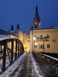 a bridge in a city with snow on the ground at Weinberg Apartments & Acquarenacard in Naz-Sciaves
