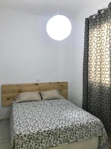1 dormitorio con 1 cama con manta blanca y negra en Rooms Arganzuela Centro, en Madrid