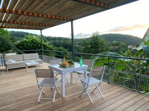 eine Terrasse mit einem Tisch und Stühlen auf einer Terrasse in der Unterkunft Les Cabanes Perchées in Bouillante