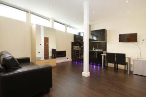 a living room with a black leather couch and a table at Cumberland Apartments in London