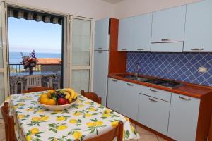 a kitchen with a table with a bowl of fruit on it at Casamareblu in Parghelia