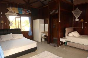 a bedroom with two beds and a refrigerator in it at Arya's Surf Camp in Sukabumi