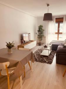 a living room with a table and a couch at Apartamento Rio San Isidro 1 in Felechosa