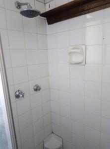 a white tiled bathroom with a toilet and a shower at Spacious 1bed + braai 13km to Paternoster beach in Vredenburg