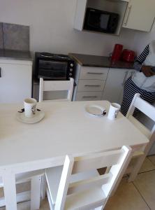 a white table in a kitchen with two cups on it at Spacious 1bed + braai 13km to Paternoster beach in Vredenburg