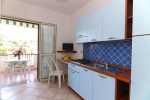 a kitchen with a sink and a table with a view at Casamareblu in Parghelia +25 photos