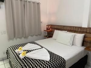 1 dormitorio con 1 cama grande y toallas. en Pousada do Mineiro, en Trancoso