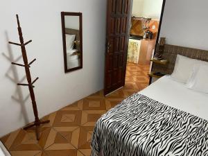 a bedroom with a bed and a mirror in a room at Pousada do Mineiro in Trancoso