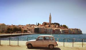 ein altes Auto, das neben einem Wasserkörper parkt in der Unterkunft Casa Casale in Rovinj