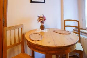 a wooden table with two chairs and a vase with flowers at Pension Paseka in Litomyšl
