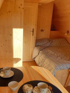 una habitación con una cama y dos tazas en una mesa en B&B La ferme du Château de Broich, en Plombières