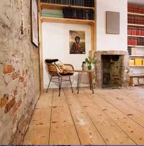 a room with a chair and a table and a fireplace at Bookstor Atelier in The Hague