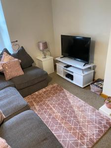 a living room with a couch and a flat screen tv at Market View in Eyemouth