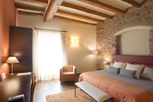 1 dormitorio con 1 cama, 1 silla y 1 ventana en Cal Barber en Botarell