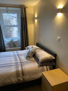a bedroom with a bed with a window and a table at Market View in Eyemouth