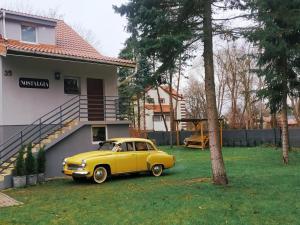 オルシュティンにあるNostalgia noclegiの家庭に停車した黄色い車