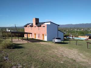 a house with a car parked in front of it at Complejo Acanto in Villa Carlos Paz