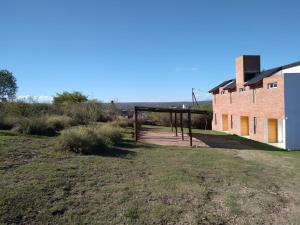 un champ vide à côté d'un bâtiment en briques dans l'établissement Complejo Acanto, à Villa Carlos Paz