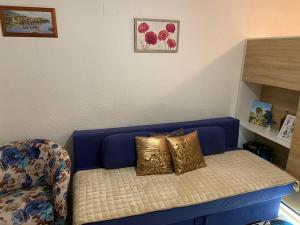 - un canapé bleu avec deux oreillers dans l'établissement Lake apartment, à Blidinje