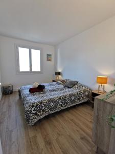 a bedroom with a bed and a wooden floor at Le Kerdun Bord de mer tout à pied in Le Pouliguen