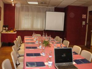 une salle de conférence avec une longue table et un ordinateur portable dans l'établissement Hotel Iris, à Granollers