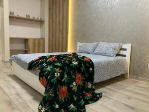 een slaapkamer met een bed met een deken erop bij VIP apartment у центрі міста, новобудЖК Театральний,дуже простора in Rivne