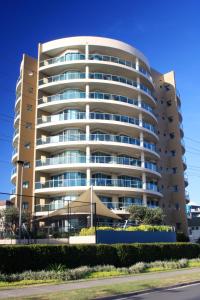 a large apartment building in front of a street at Sails Apartments in Forster
