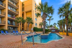 a swimming pool in front of a building with palm trees at Direct oceanfront, separate bedroom condo, 9th floor, unbelievable views! in Myrtle Beach