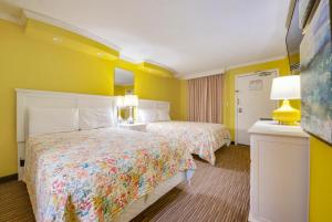 two beds in a hotel room with yellow walls at Direct oceanfront, separate bedroom condo, 9th floor, unbelievable views! in Myrtle Beach +30 photos