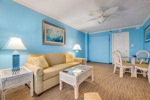 a living room with a couch and a table at Direct oceanfront, separate bedroom condo, 9th floor, unbelievable views! in Myrtle Beach