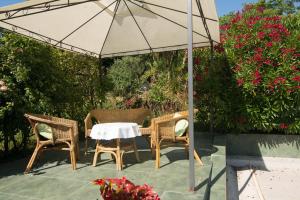 stół i krzesła pod parasolem na patio w obiekcie Villa Anna w mieście Savudrija
