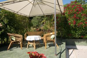 una mesa y sillas bajo una sombrilla en un patio en Villa Anna, en Savudrija